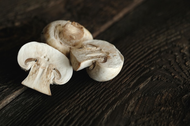 Funghi champignon freschi sulla tavola di legno, primo piano.