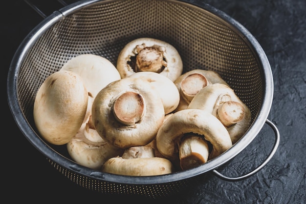 Funghi champignon in scolapasta in metallo