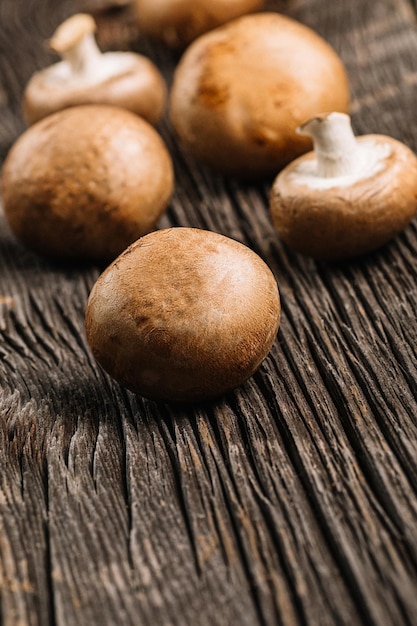 Funghi champignon marroni freschi pronti per la cottura su un vecchio tavolo di legno