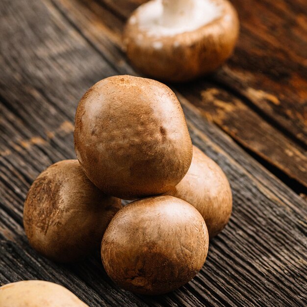 Funghi champignon marroni freschi pronti per la cottura su un vecchio tavolo di legno