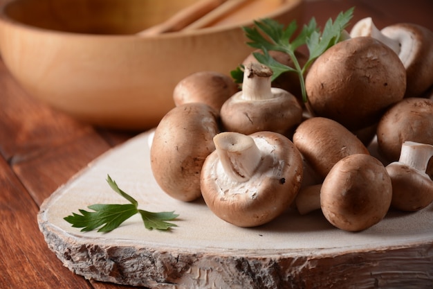 Funghi champignon marroni freschi su tavola di legno