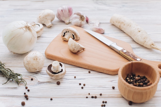 Funghi con diversi ingredienti bianchi sul tavolo in legno, vista dall&#39;alto e distesi.