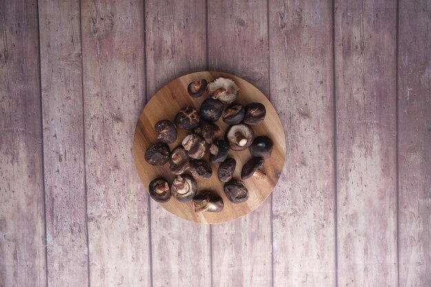 Funghi crudi di champignon su una tavola da taglio su tavola