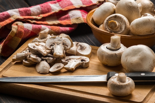 Funghi crudi su un tagliere di legno