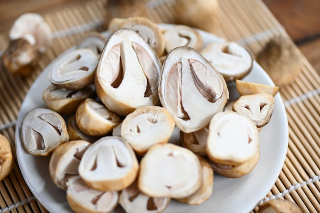 Funghi di paglia sul piatto bianco Fetta di funghi freschi per cucinare il cibo