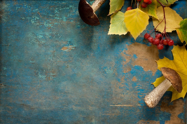 Funghi e foglie di autunno su un tavolo di legno