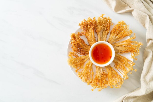 funghi enoki fritti o funghi aghi dorati con salsa piccante - stile alimentare vegano