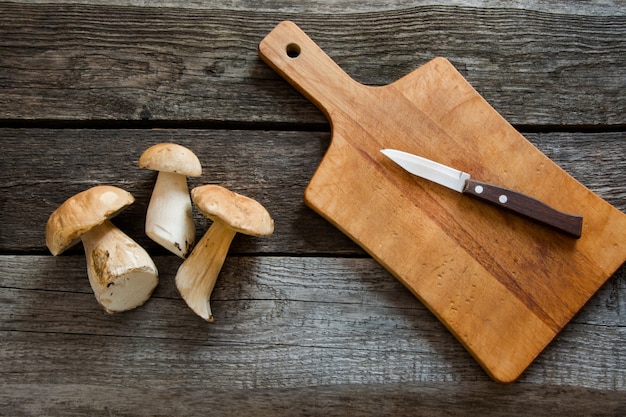 Funghi freschi bianchi dalla foresta sul bordo di legno rustico. Vista dall&#39;alto.