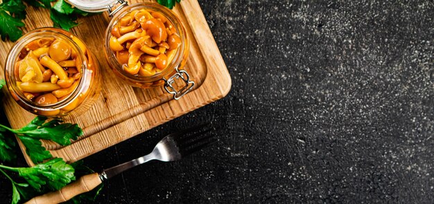 Funghi marinati al prezzemolo su tagliere di legno