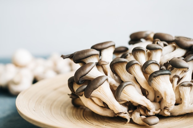 Funghi ostrica fresca sul piatto di legno, primi piani.