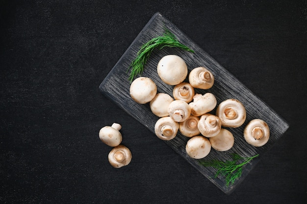 Funghi prataioli crudi dei funghi su una tavola di legno
