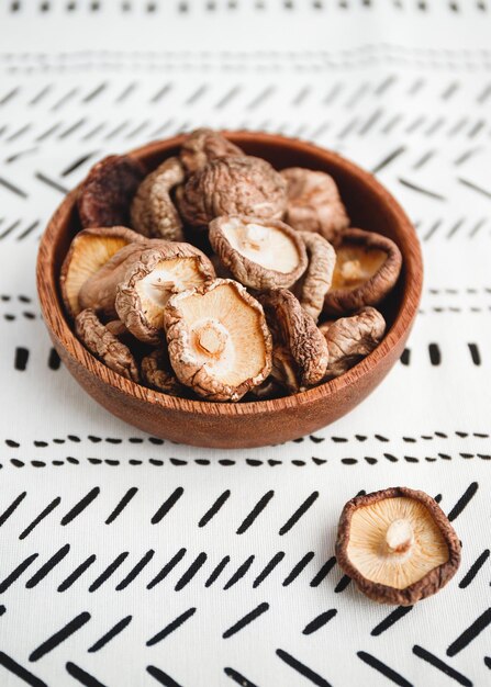 Funghi secchi cinesi Shiitake in una ciotola di legno su un tavolo Il concetto di supercibi medicinali per la salute Vista dall'alto piatto