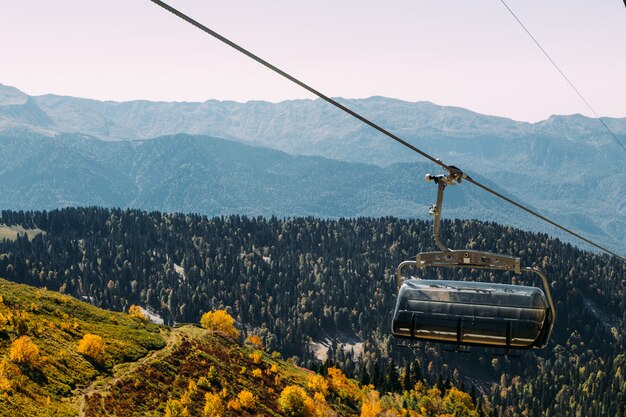 Funicolare alto nelle montagne sopra la foresta di autunno