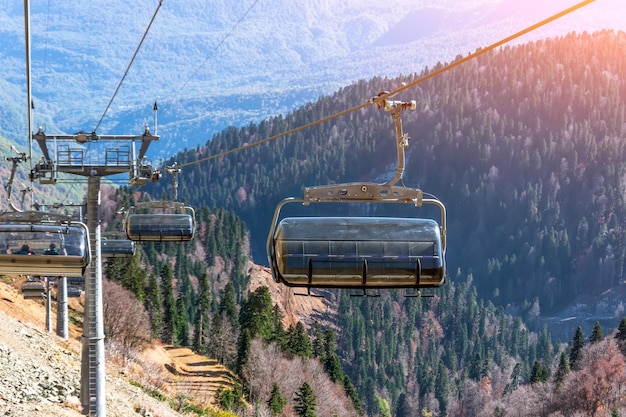 Funivia con impianti di risalita e cabine per i turisti con vista sulla città e sulla foresta autunnale in montagna