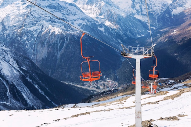 Funivia con sedili luminosi in splendide montagne innevate in una limpida giornata di sole. Turismo attivo e sport invernali. Paesaggio magnifico.