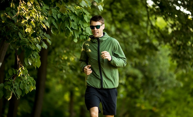 Funzionamento atletico del giovane mentre facendo allenamento in parco verde soleggiato