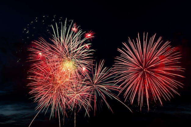 Fuochi d'artificio colorati luminosi su un concetto nero di celebrazione e di feste del fondo