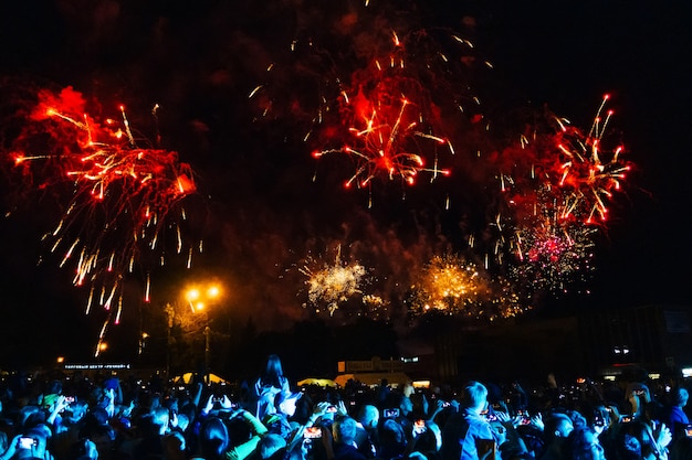 Fuochi d'artificio colorati nel cielo notturno e folla al concerto di Kineshma