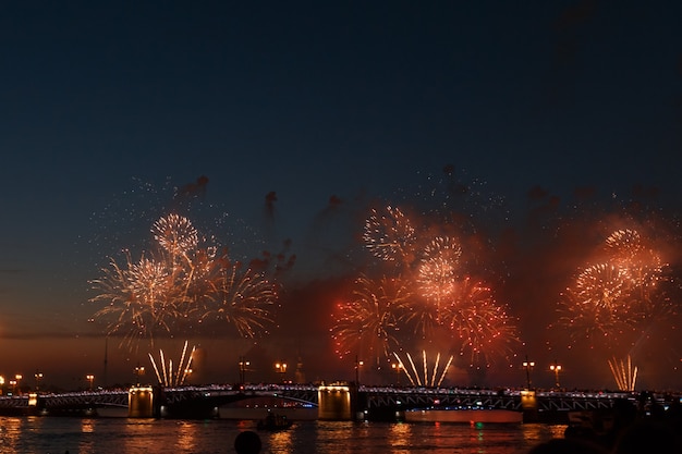 Fuochi d'artificio colorati riflettono dall'acqua, uno splendido scenario del ponte