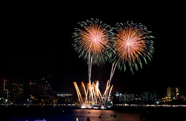 Fuochi d'artificio di felice anno nuovo sopra paesaggio urbano di notte. festa celebrazione festa