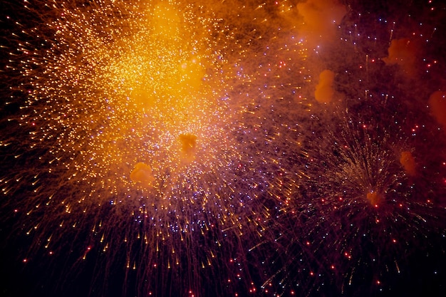 Fuochi d'artificio luminosi arancioni e blu sullo sfondo del cielo notturno