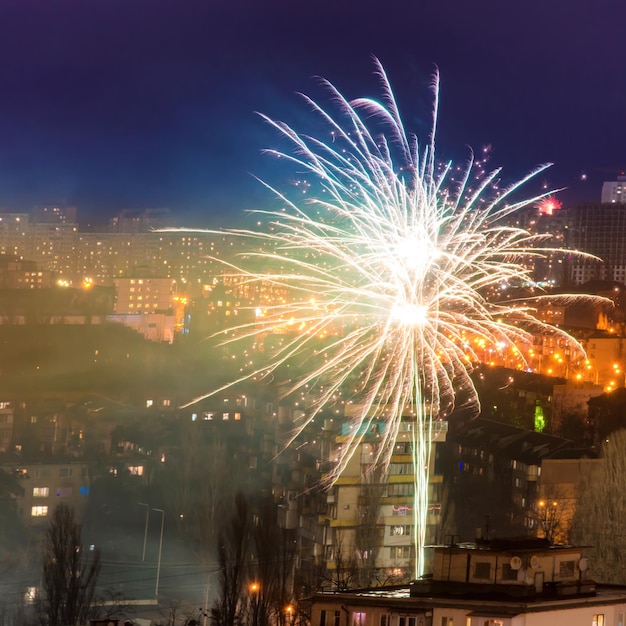 Fuochi d'artificio per le vacanze in una città con cielo notturno blu