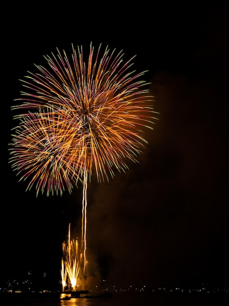 Fuochi d'artificio sullo sfondo del cielo scuro neroCelebrare la festa Buon Natale e felice anno nuovo FestivalLuce brillante Bokeh Oro astratto Scoppio fuoco Anniversario Compleanno Vacanze Carta da paratiNotte colorata