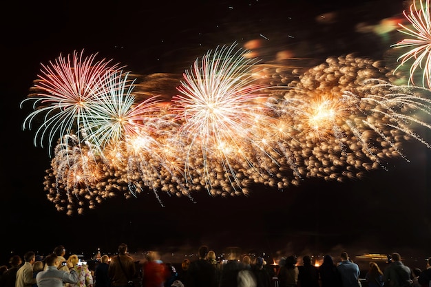 Fuochi d'artificio vacanza vicino al fiume sullo sfondo del cielo nero