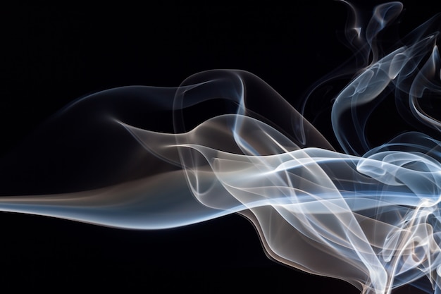 Fuoco dell&#39;estratto blu e bianco del fumo su fondo nero, concetto di oscurità