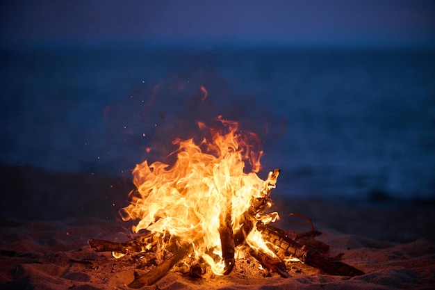 Fuoco selettivo del falò della spiaggia con bel tramonto o alba nessuno