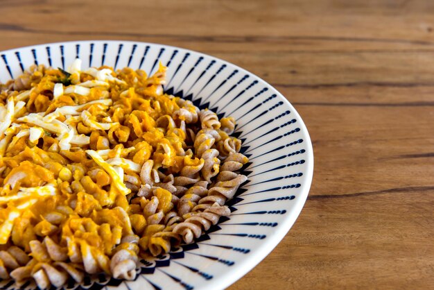 Fusilli con salsa di zucca e formaggio coloniale delizioso cibo fatto in casa sul tavolo di legno