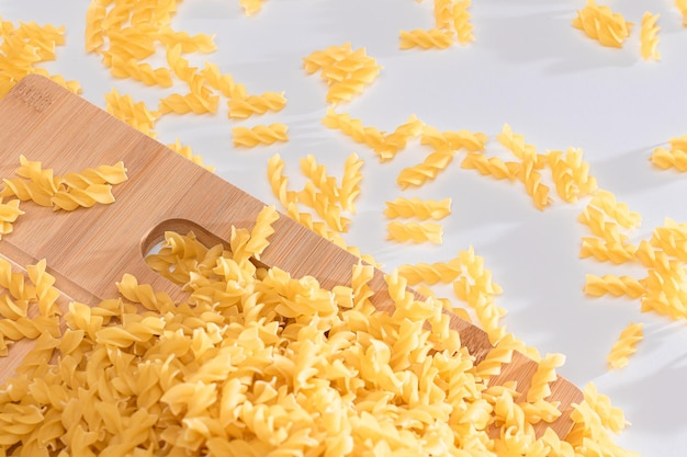 Fusilli crudi sparsi su tavola di legno