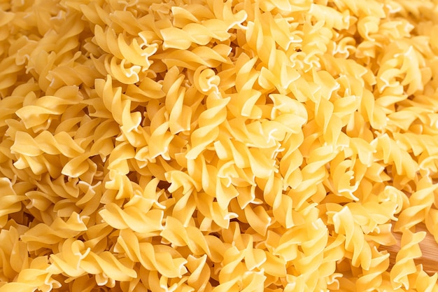 Fusilli crudi sparsi su tavola di legno