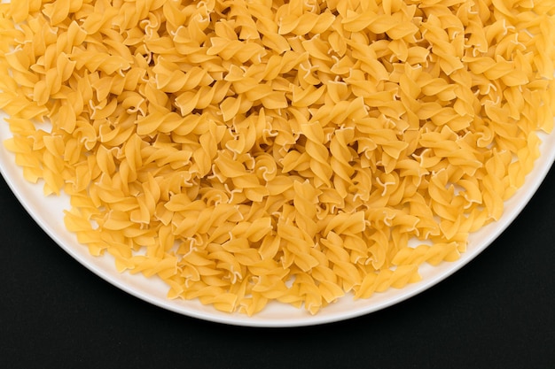 Fusilli crudi su piatto bianco