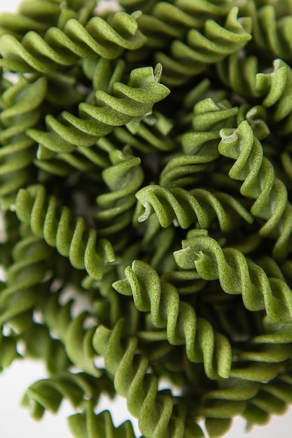 Fusilli crudi verdi, al naturale a base di spinaci e spirulina. Cibo delizioso e sano. Avvicinamento.