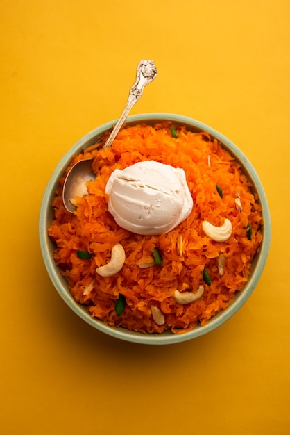 Galar Halwa con gelato alla vaniglia, servito in una ciotola e guarnito con frutta secca. messa a fuoco selettiva