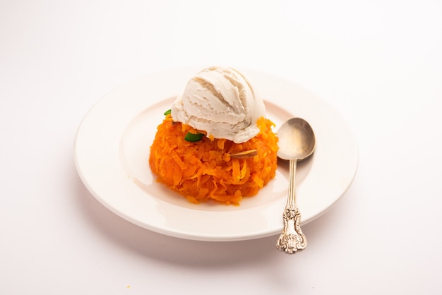 Galar Halwa con gelato alla vaniglia, servito in una ciotola e guarnito con frutta secca. messa a fuoco selettiva