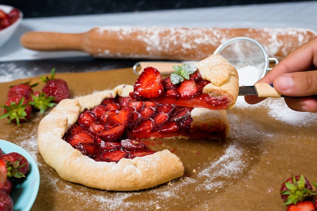 Galette alla fragola fatta in casa con fragole mature fresche su un buio.