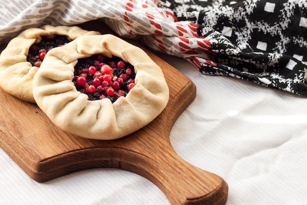 Galette dolce fatta in casa con bacche di sambuco e mirtilli rossi su una tavola di legno