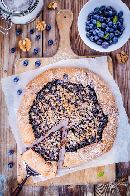 Galette fatta in casa con mirtilli e noci su tavola rustica in legno