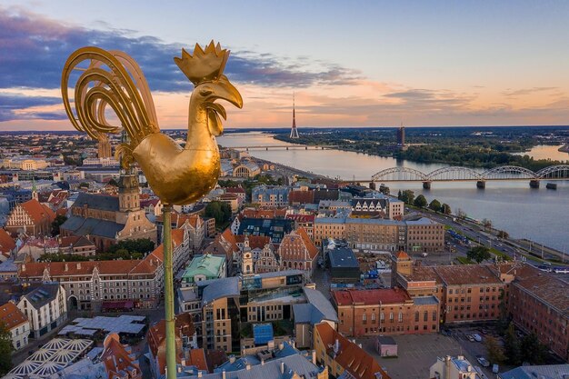 Gallo d'oro, statua del gallo, sopra la città vecchia di Riga in Lettonia. Vista aerea.