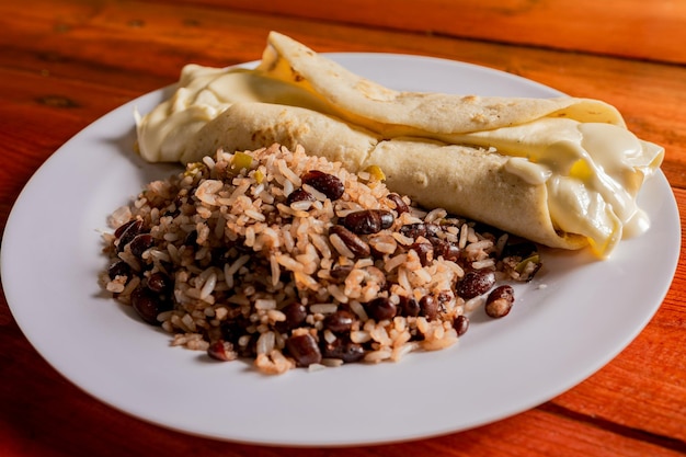 Gallo pinto tradizionale con quesillo servito su tavola di legno Gallopinto nicaraguense con quesillo sul tavolo cibi tipici nicaraguensi