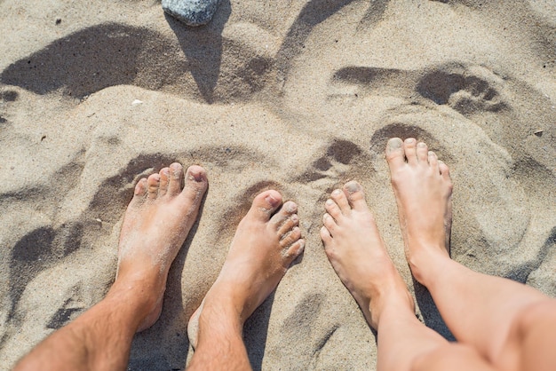 Gambe a piedi nudi sulla sabbia, primo piano