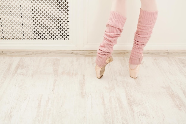 Gambe del ballerino di balletto che indossa il primo piano delle ghette. Giovane ballerina che si prepara per la pratica nella scuola di danza classica, utilizzando un panno speciale