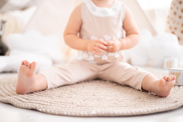 Gambe del bambino di un primo piano sano del bambino sullo sfondo del soggiorno a casa