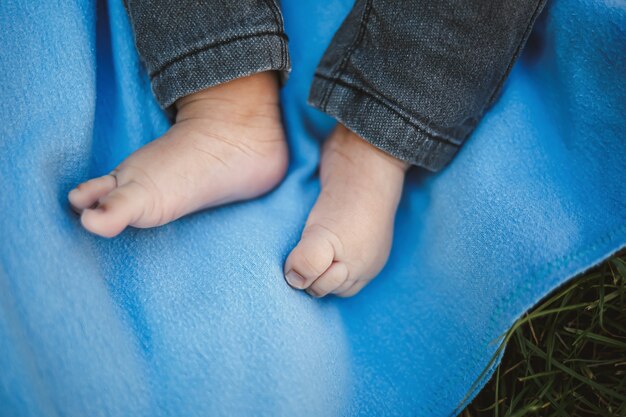 Gambe del bambino su un copriletto blu.