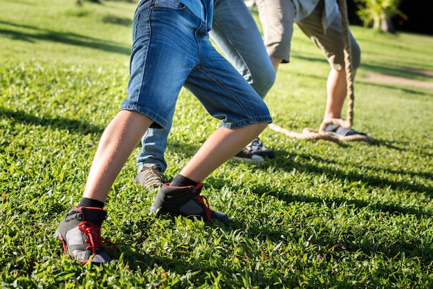 Gambe del primo piano della famiglia che gioca a calcio