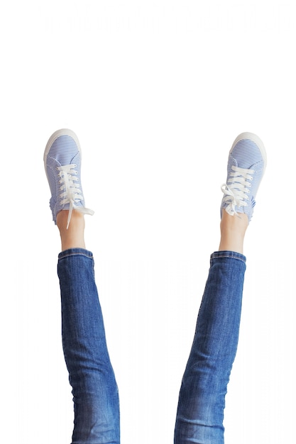 Gambe della donna in blue jeans su bianco isolate