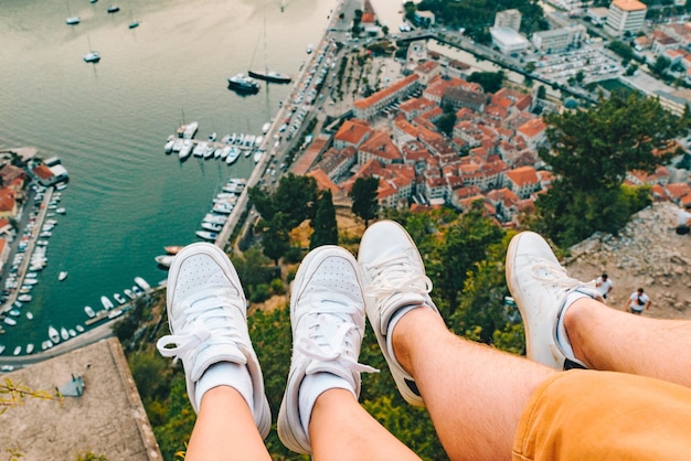 Gambe di coppia in collina con splendida vista della città di Kotor sullo sfondo