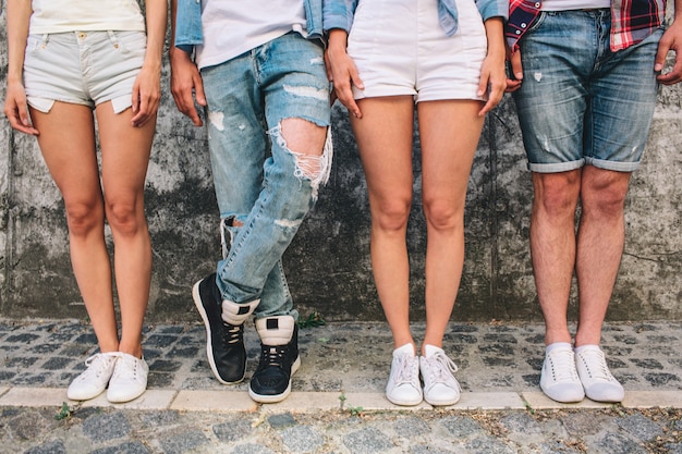 Gambe di persone in jeans e pantaloncini